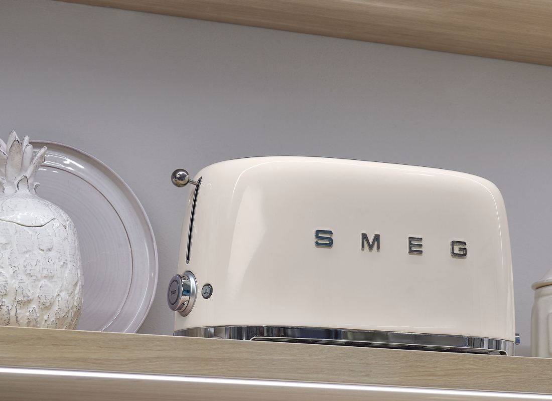 SMEG-Toaster im 50s-Style-Design in creme platziert auf einem Regal. SMEG-Toaster im 50s-Style-Design in creme platziert auf einem Regal.