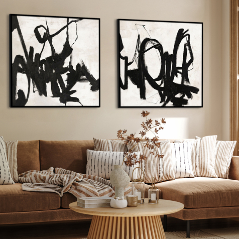 Wanddekoration Wohnzimmer mit Couch, darüber zwei Wandbilder mit abstrakter Kunst.